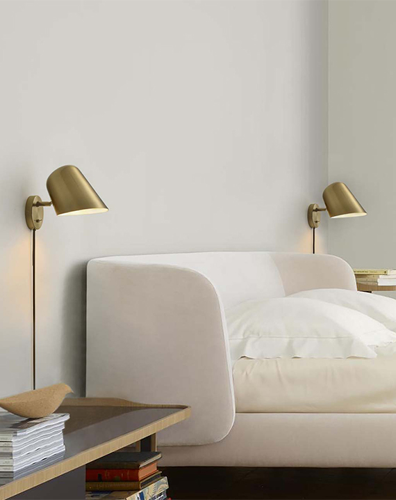 Chic Culver Wall Sconce in Brushed Brass: Adjustable shade for focused lighting. Glare-free LED illumination. Sleek design for modern interiors.